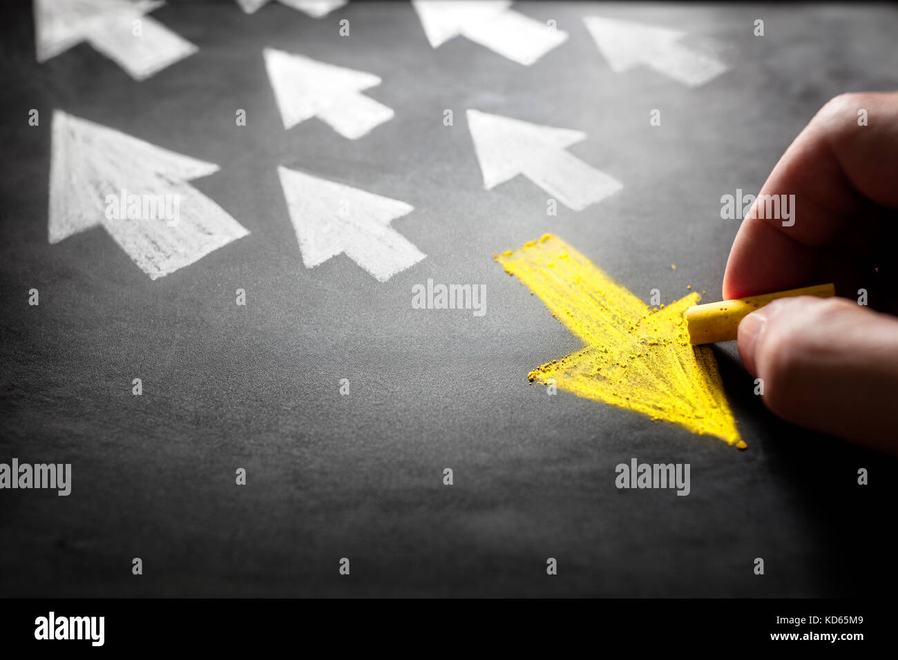 Individuality chalk arrow going a different direction on blackboard Stock Photo