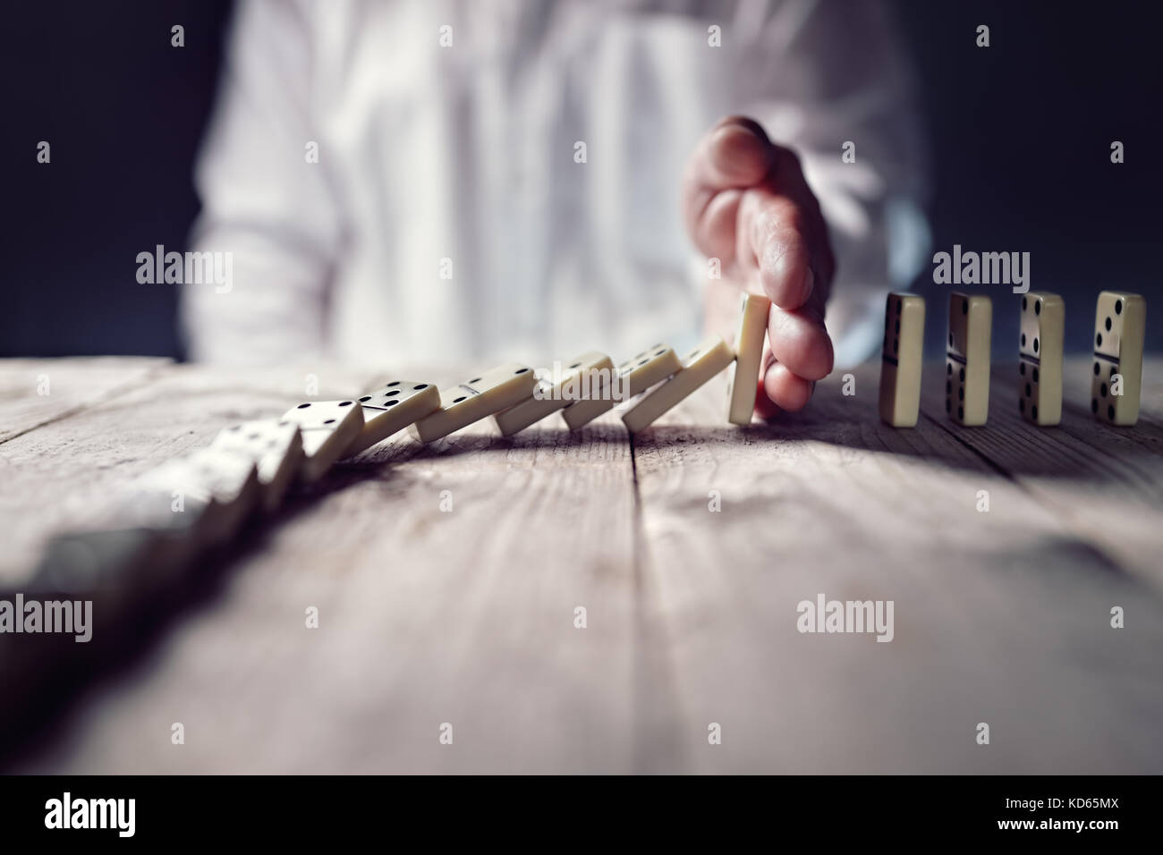 Stopping the domino effect concept for business solution, strategy and successful intervention Stock Photo