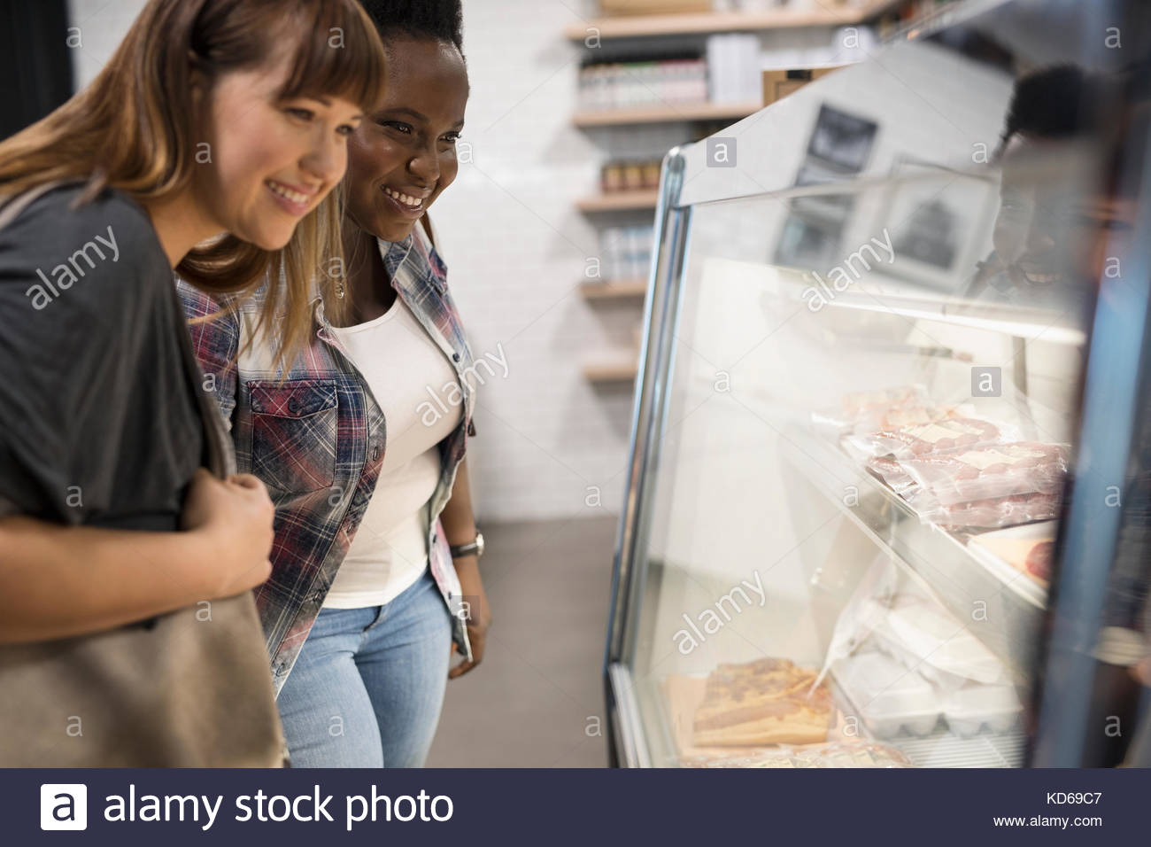 Female customers browsing meat in display case in butcher Stock Photo