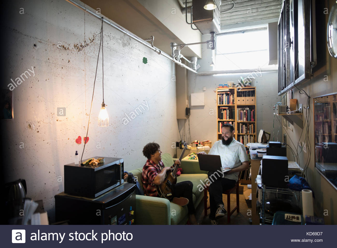 Musicians playing guitar, using laptop in apartment Stock Photo Alamy