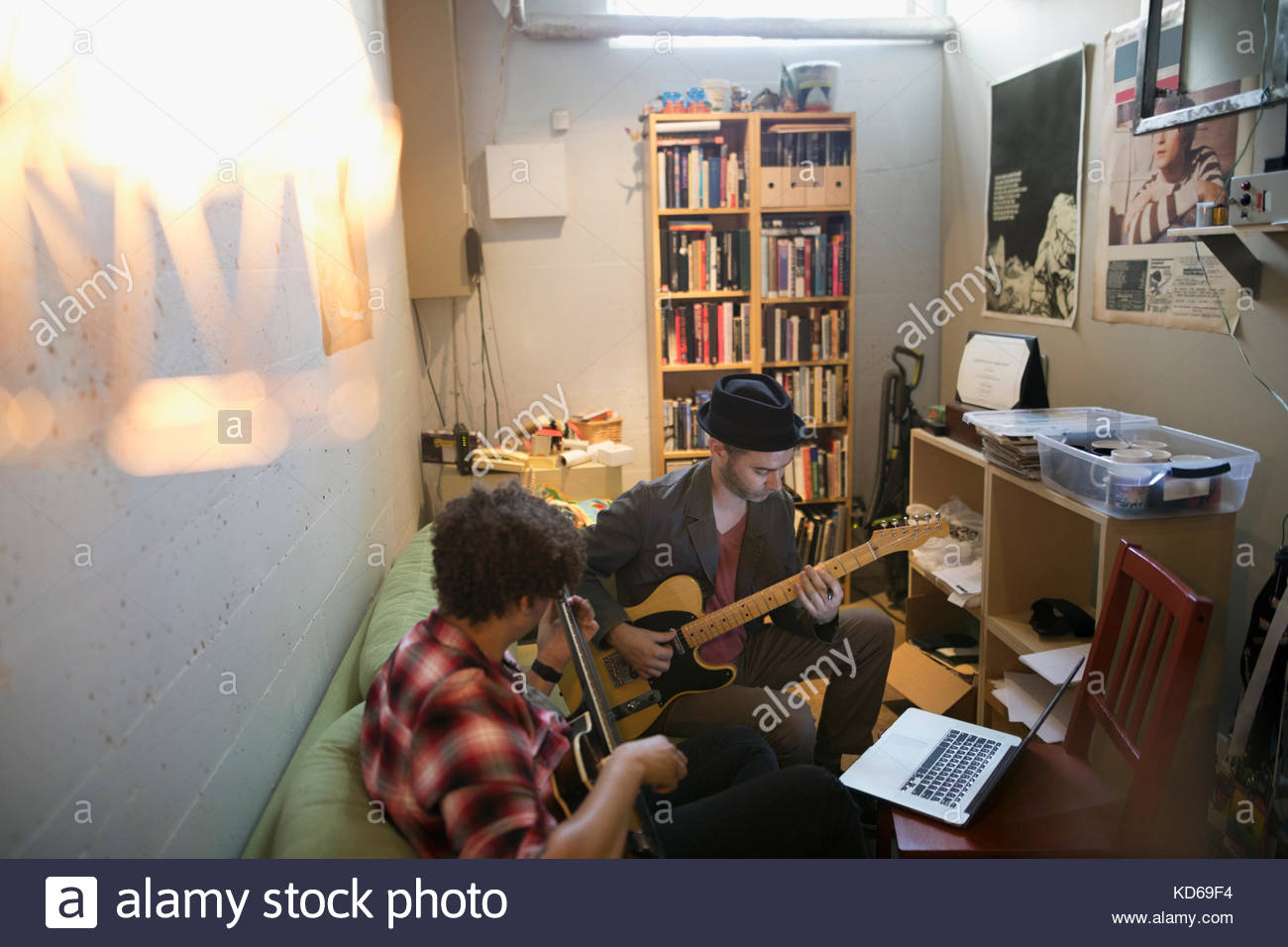 Musicians playing guitars at laptop in apartment Stock Photo Alamy