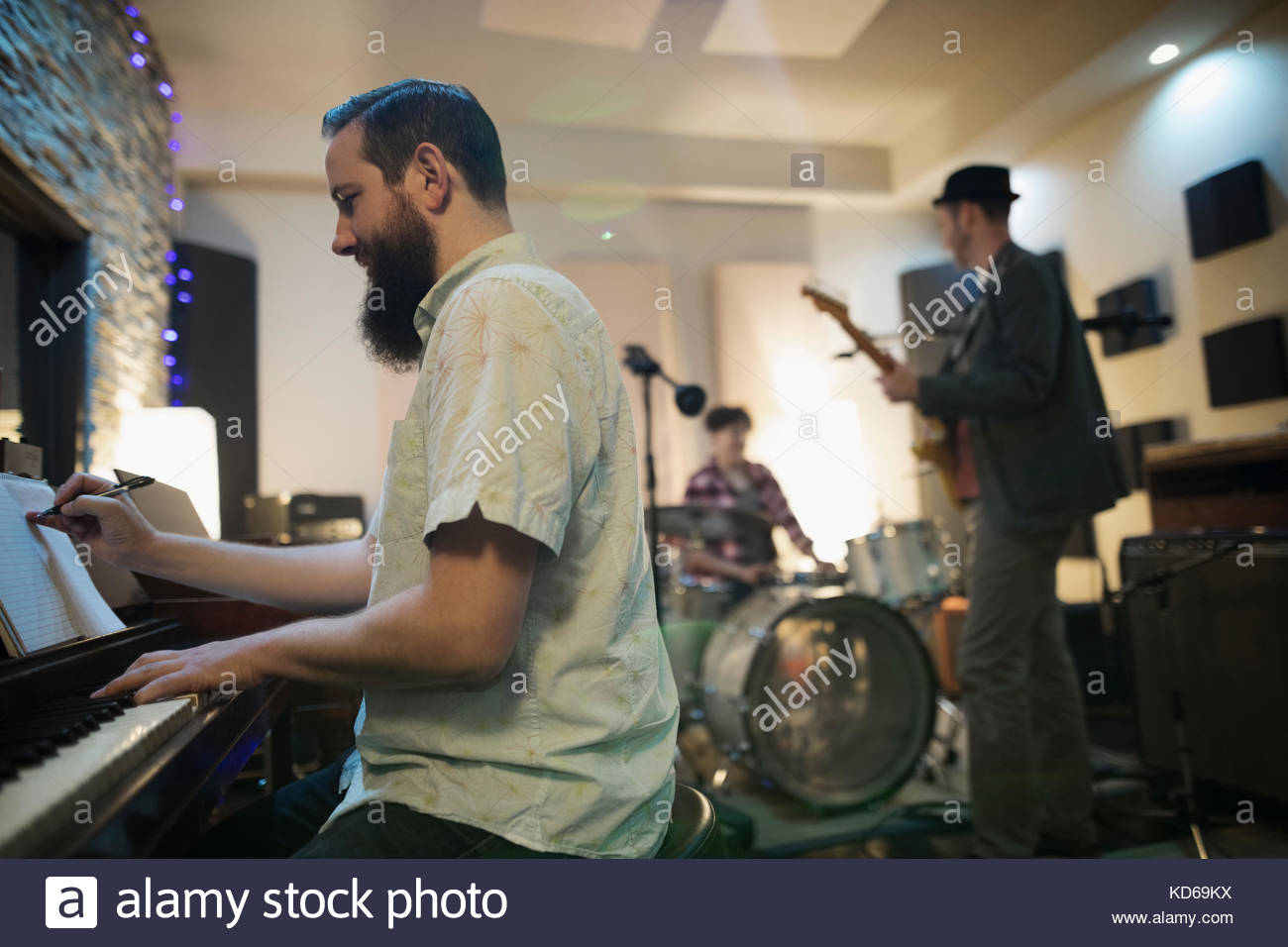 Male pianist writing music, playing in recording studio Stock Photo