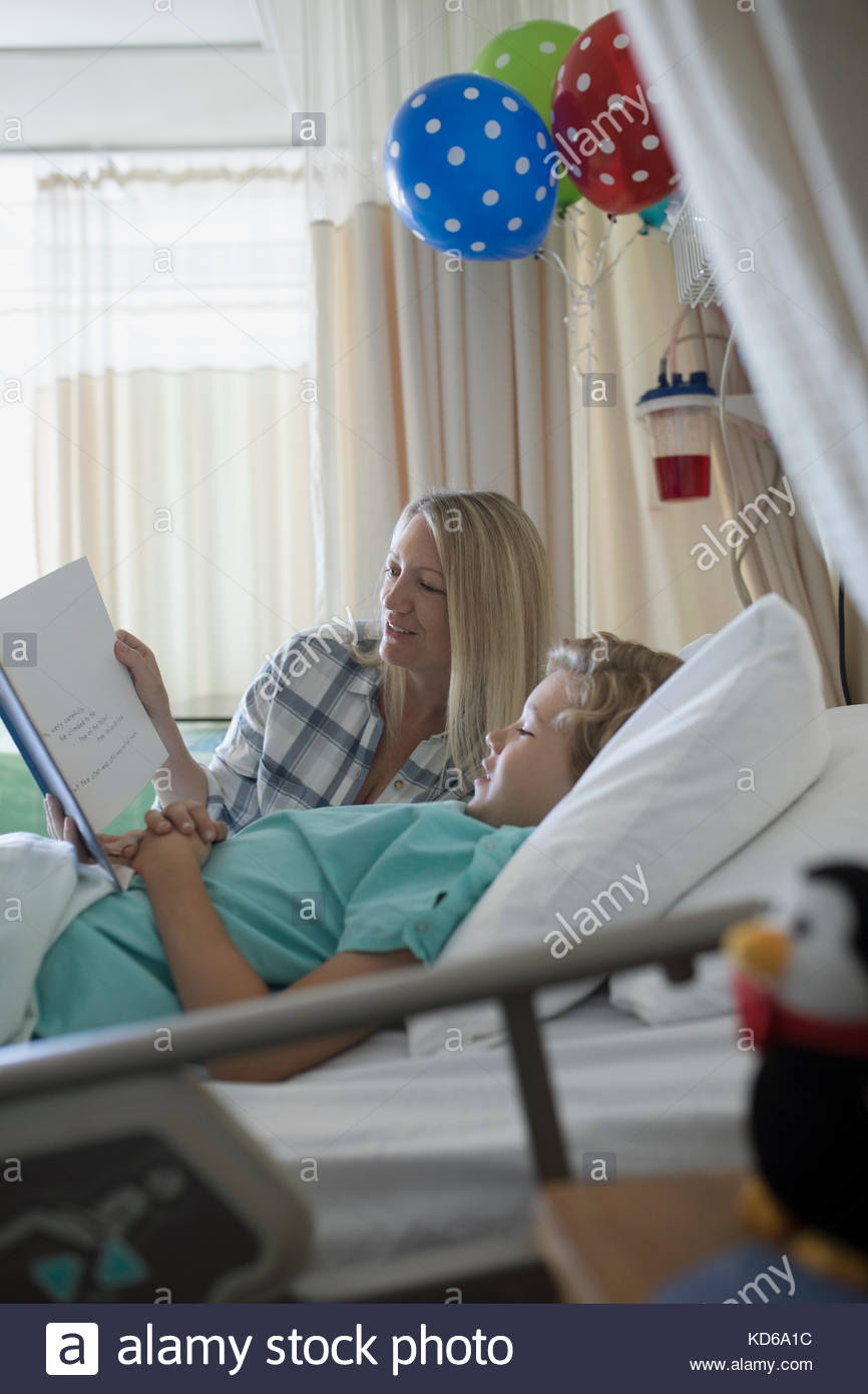 Mother and son boy patient reading book in hospital Stock Photo