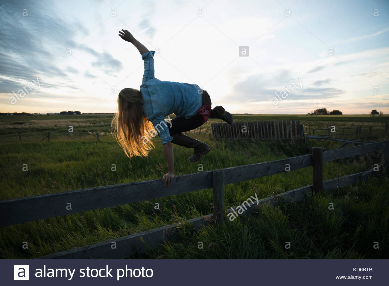 Woman jumping over fence hi-res stock photography and images - Alamy