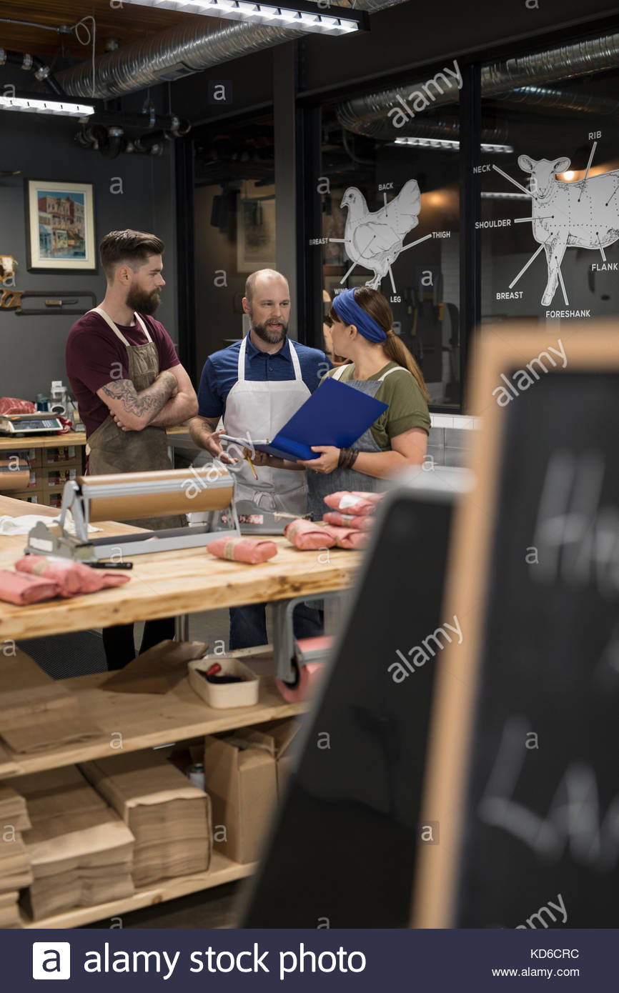 Butchers discussing paperwork in butcher Stock Photo Alamy