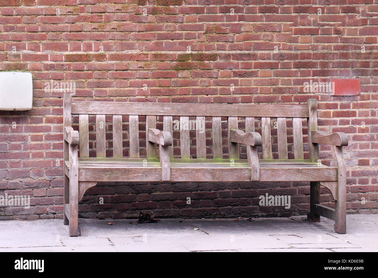 Retro wooden bench with brick wall in background Stock Photo - Alamy