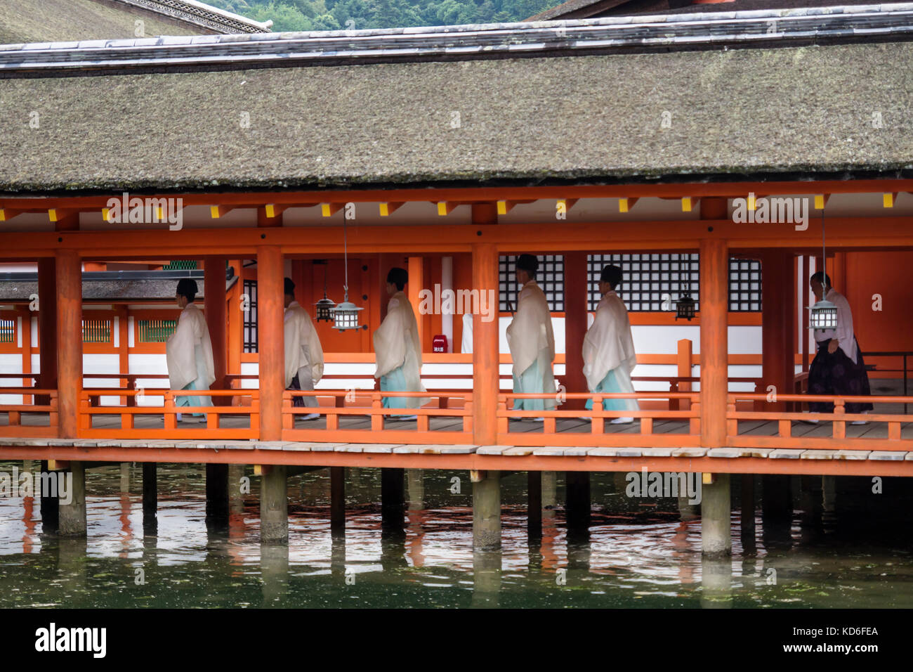 Miyajima, Japan - September 14 2017: Monks with traditional clothing in itsukushima shrine with reflections in the water Stock Photo