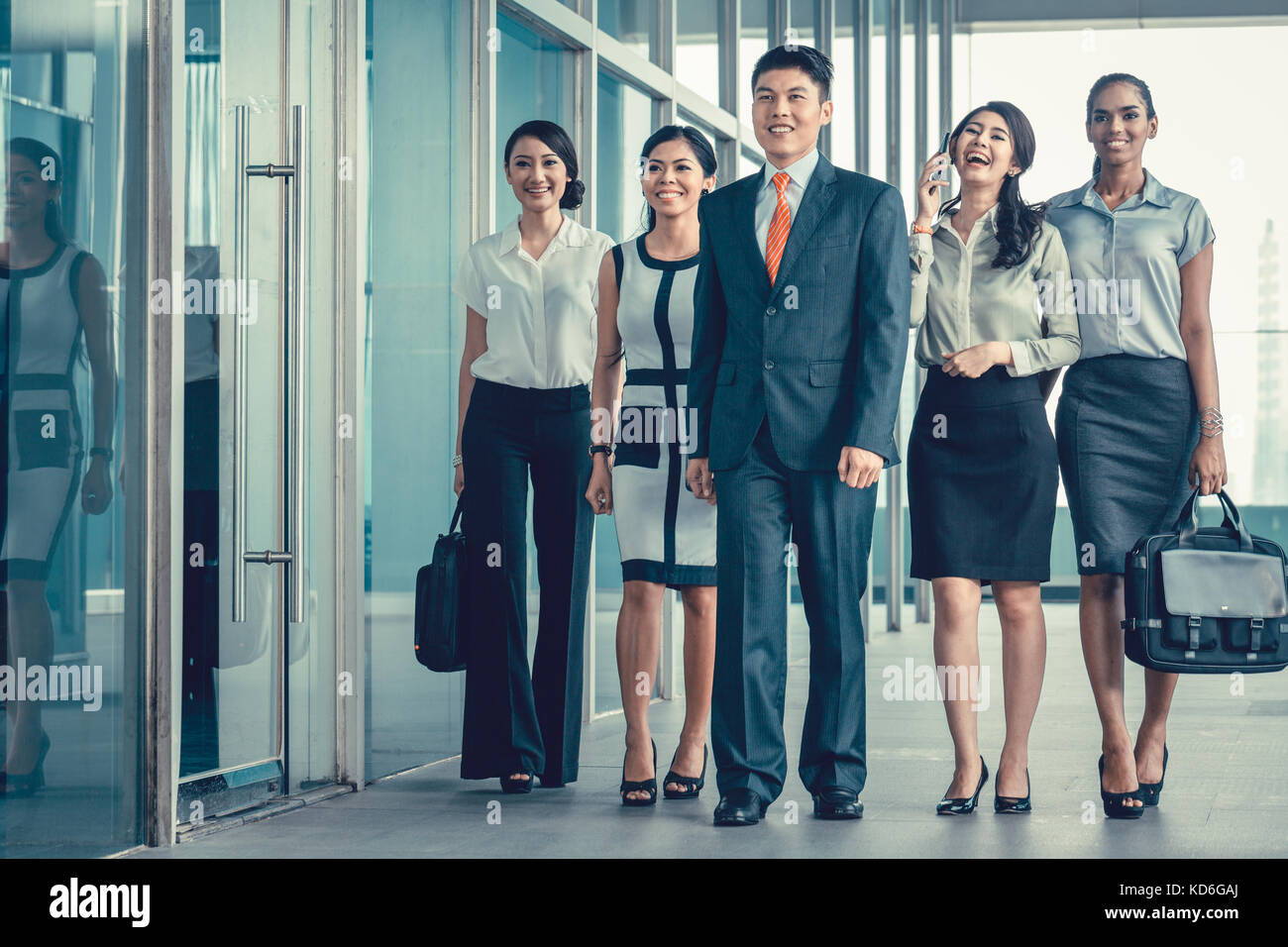 Asian business team of executives walking into office very deter Stock Photo