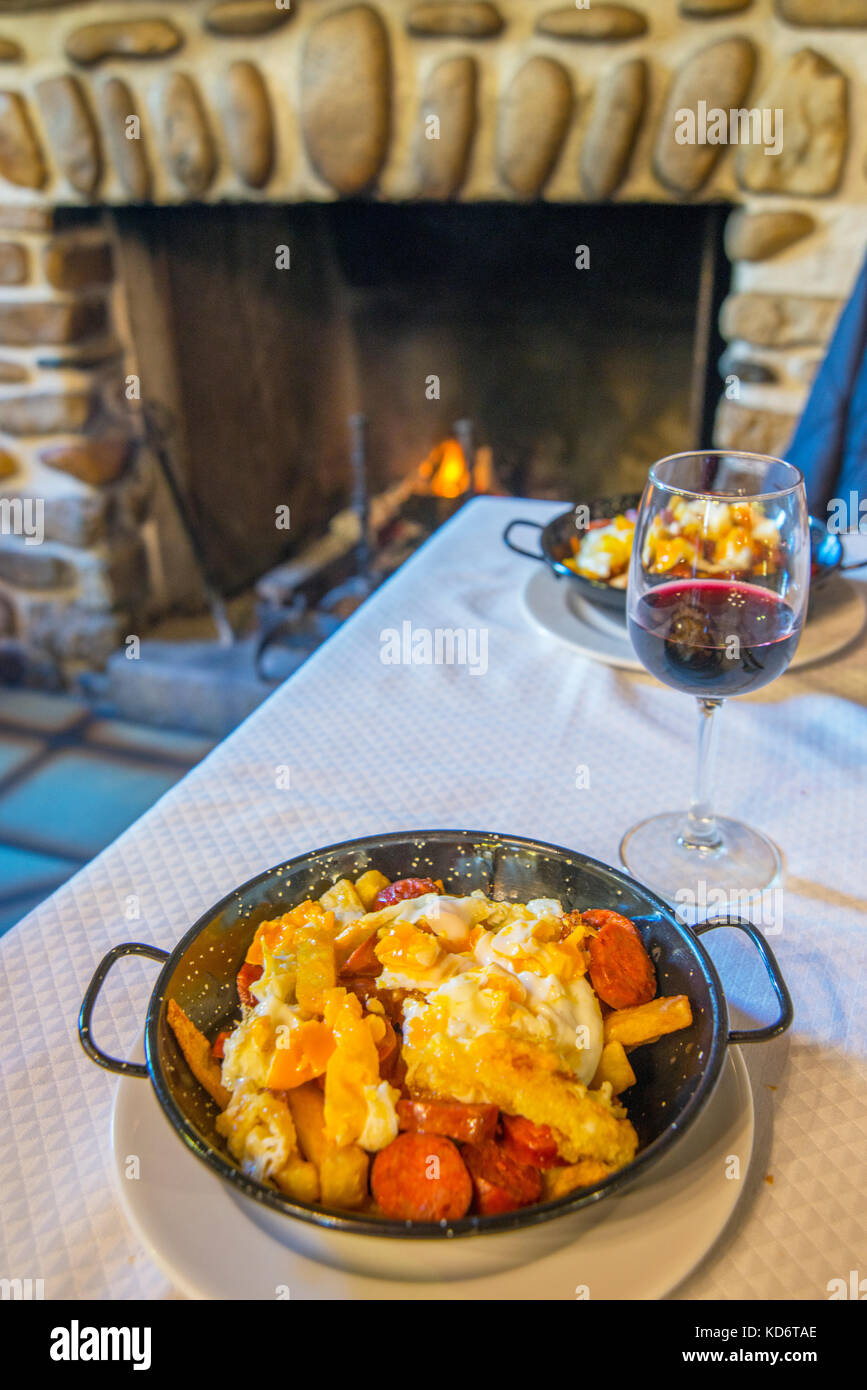 Fried eggs with potatoes and chorizo in a restaurant. Rascafria, Madrid province, Spain. Stock Photo