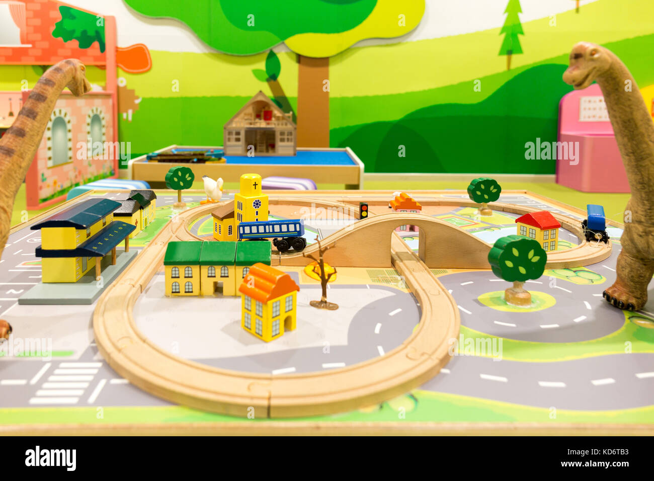 Toys for Kids, Dinosaurs Looking at Children's Railway Structure and Houses. Stock Photo