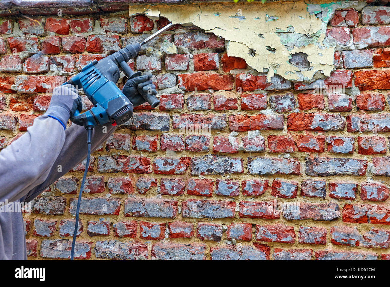 Worker with electrical hammer cleaning red brick wall outdoor Stock Photo Alamy