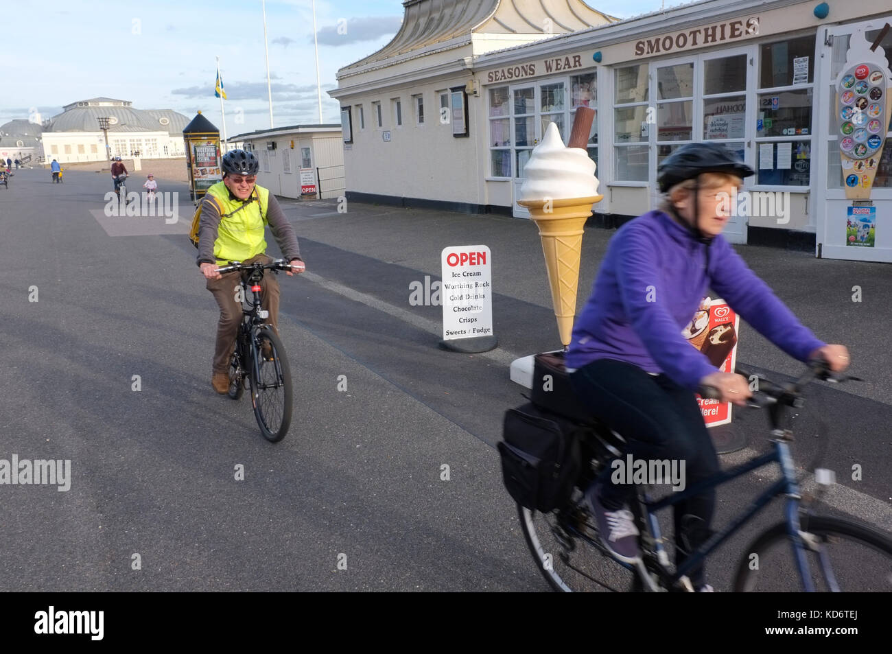 Two pensioners cycling on Worthing seafront Stock Photo