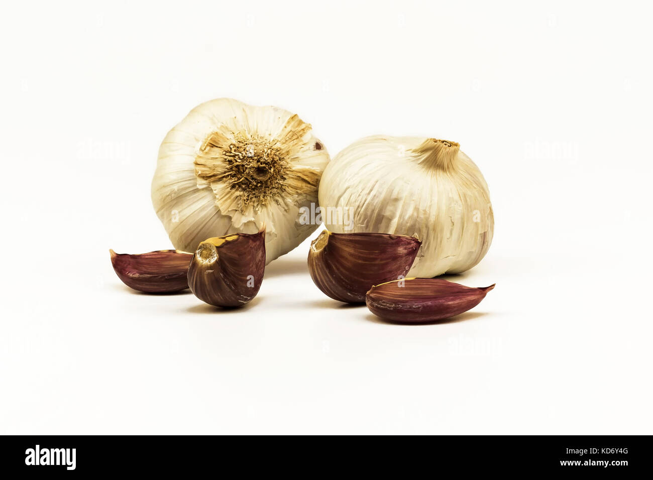 On a white background lie heads and raw garlic cloves Stock Photo