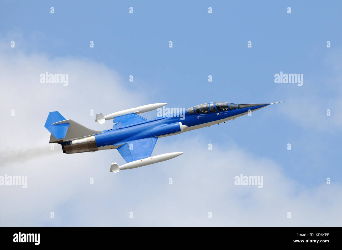 Speeding jetfighter soaring though the blue sky Stock Photo