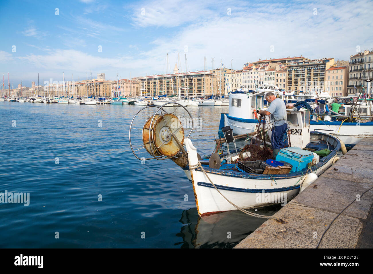 Fisherman pulling fish out of the net in Vieux Port (Old Port) on market day, Marseille, France Stock Photo