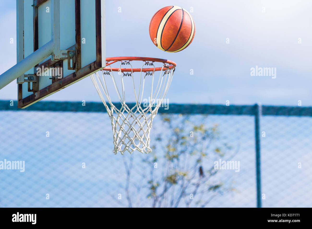 basketball floating about to get in the hoop at an outdoor basketball