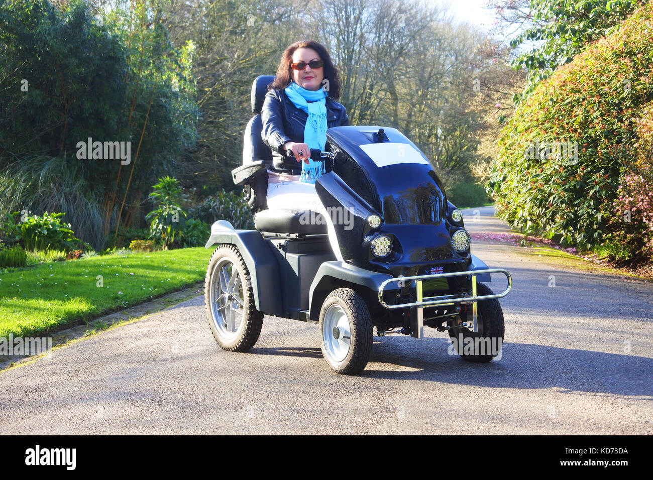 Attractive female using a motorised wheelchair - John Gollop Stock Photo