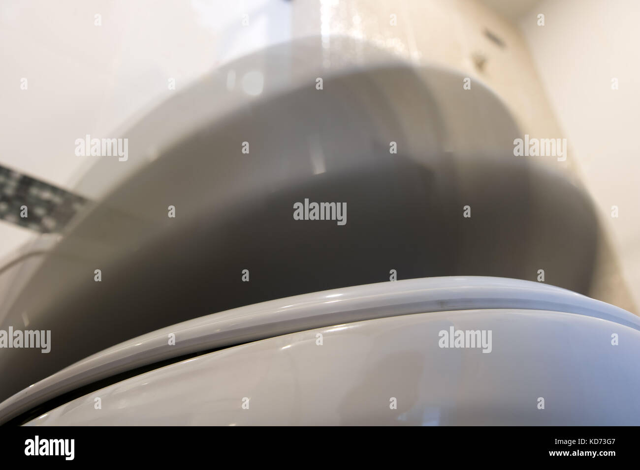 The toilet seat with lid moving down. The toilet bowl cover fall down