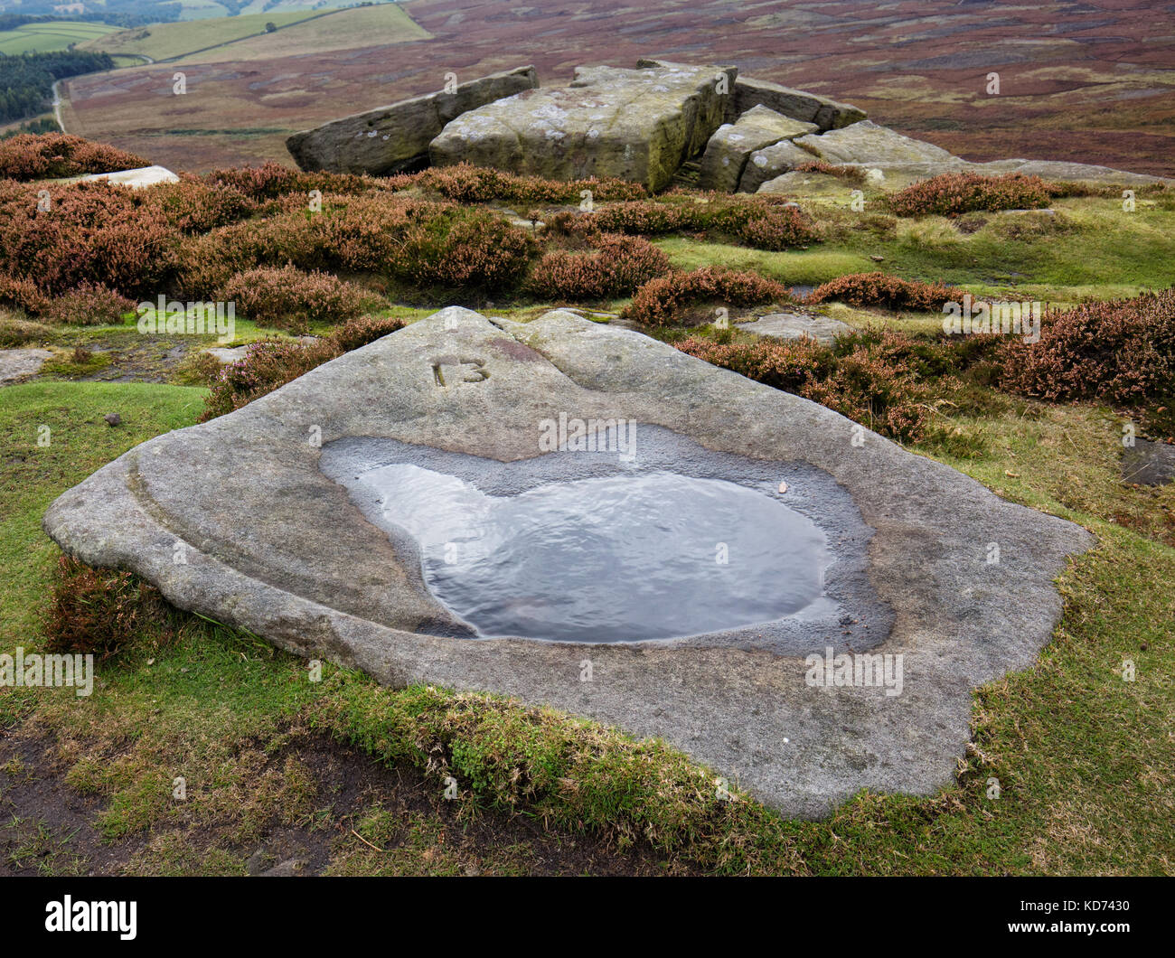 Numbered carved rock basin 13 on Stanage Edge near Hathersage in the Derbyshire Peak District - made to supply water for the grouse on Hallam Moors Stock Photo