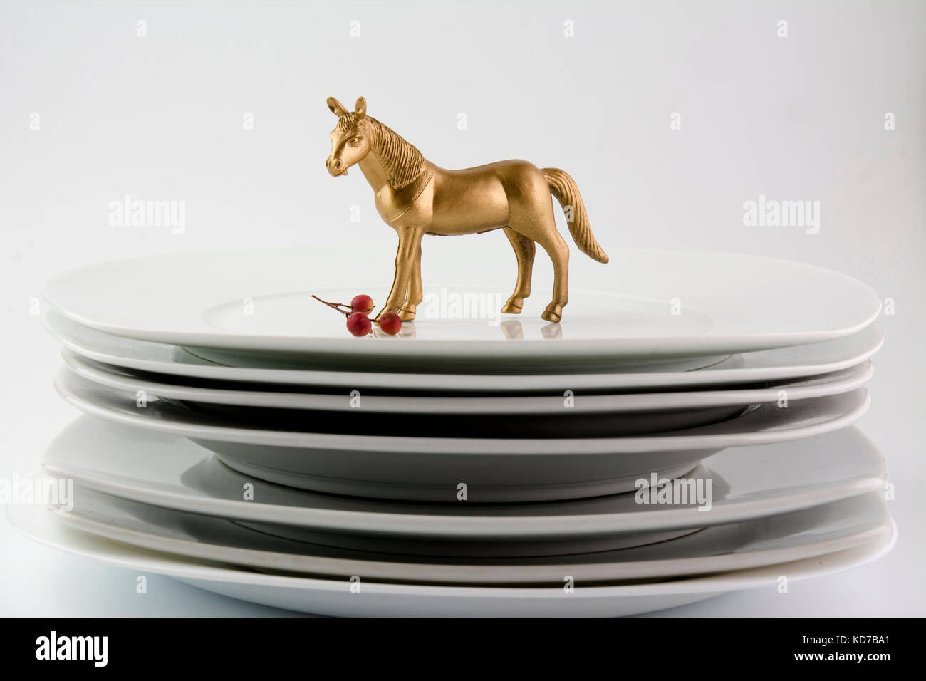 Dishes Plates stacked white and clean tableware and gold horse, conceptual food Stock Photo