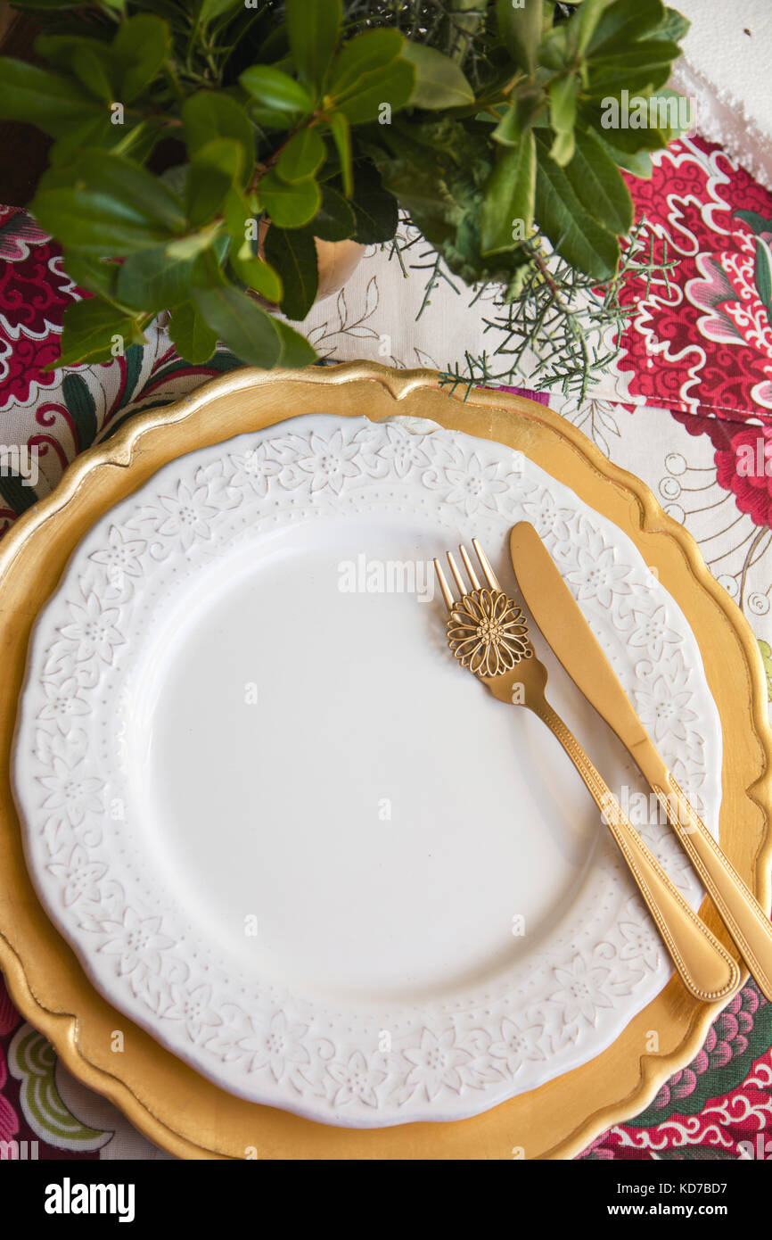 christmas place setting, table ready for lunch, on golden plates and ...