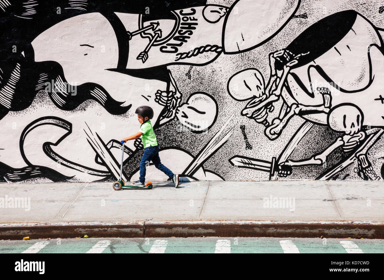 Boy on a scooter in front of graffiti in Brooklyn, New York Stock Photo