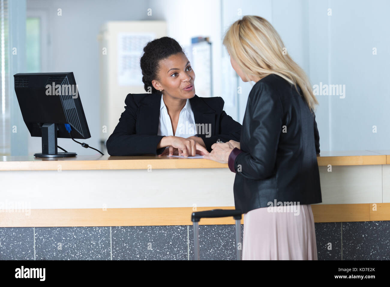 woman asking a receptionist Stock Photo - Alamy
