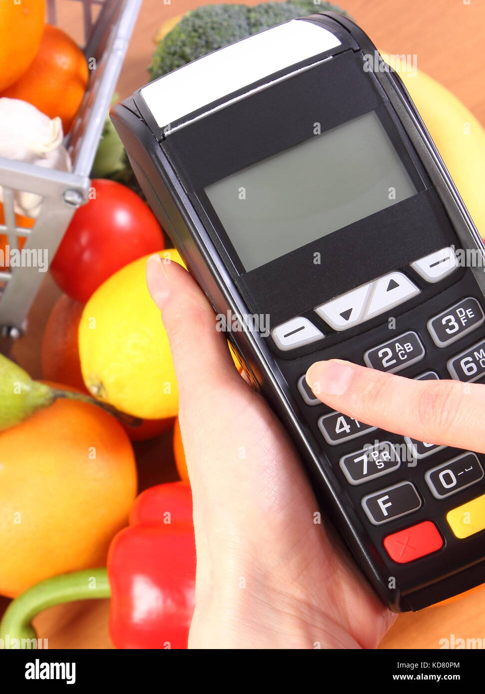 Enter personal identification number on payment terminal and fresh fruits with vegetables Stock Photo