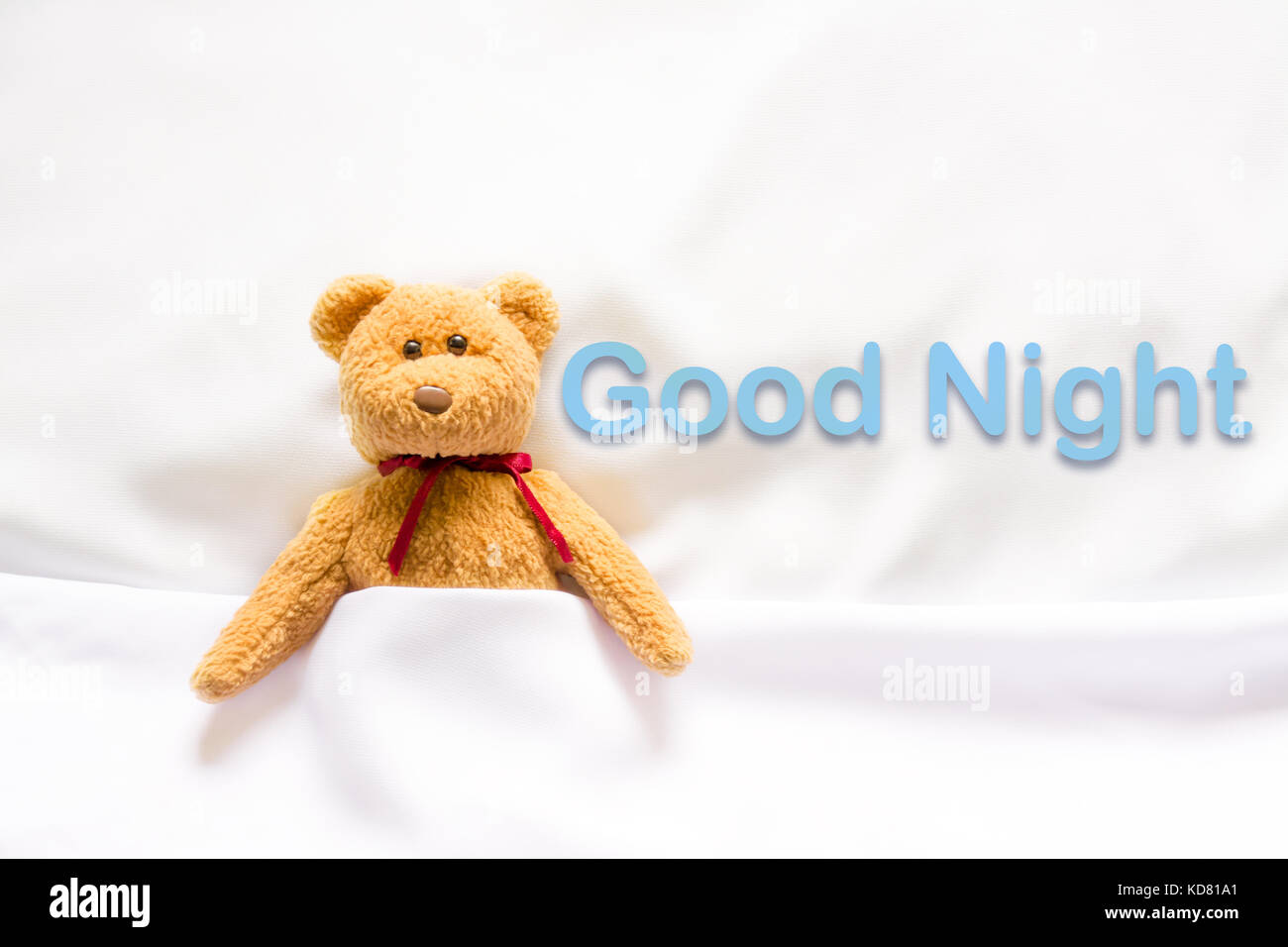 Teddy Bear lying in the white bed with message 