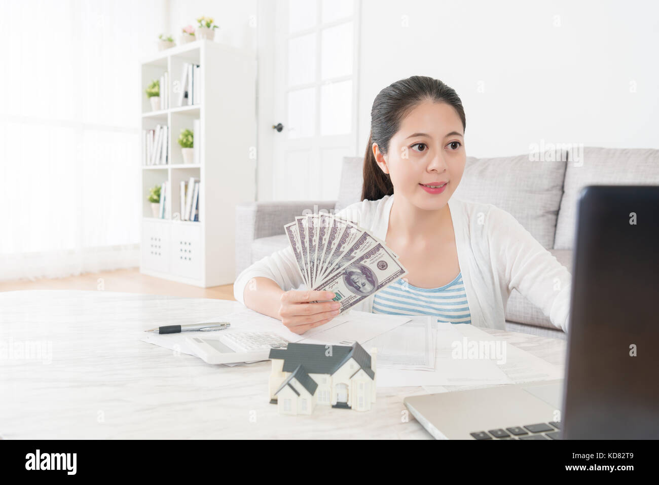 elegant attractive housewife using mobile computer laptop in living ...
