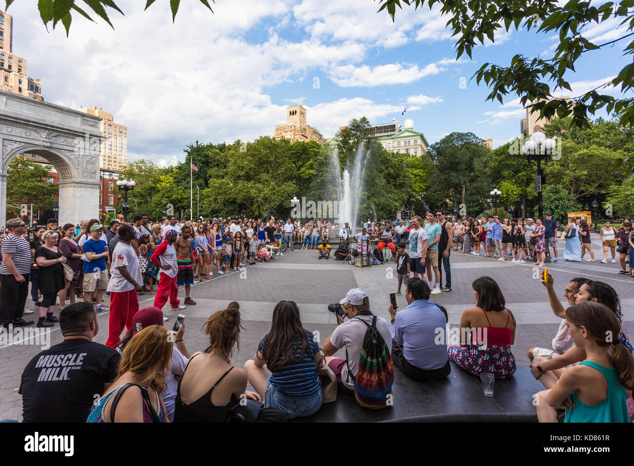 NEW YORK CITY - JULY 3, 2017: People enjoy some street performance in the Washington square park in the heart of Manhattan on a sunny summer Sunday in Stock Photo