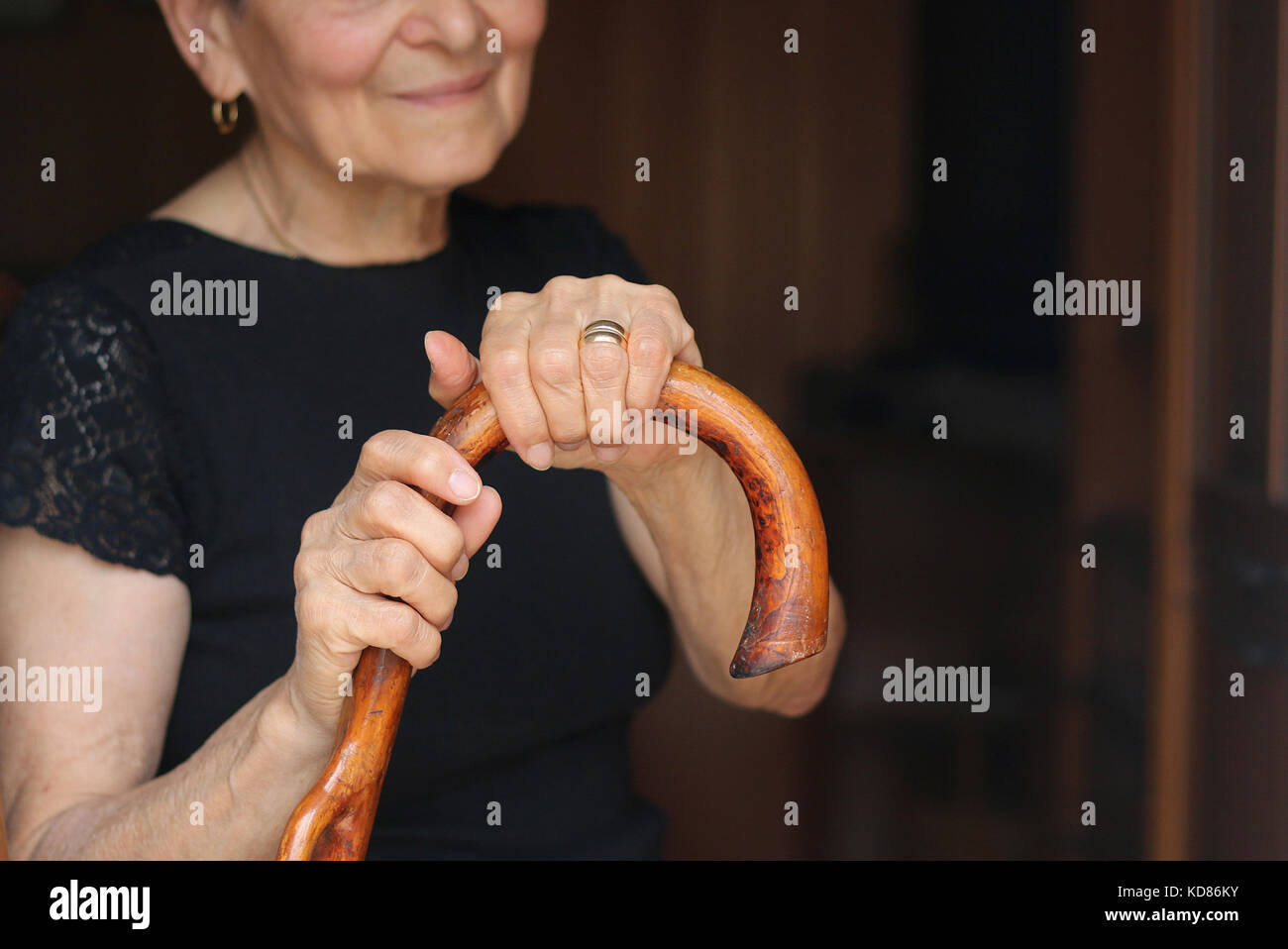 Senior woman holding a walking stick Stock Photo - Alamy