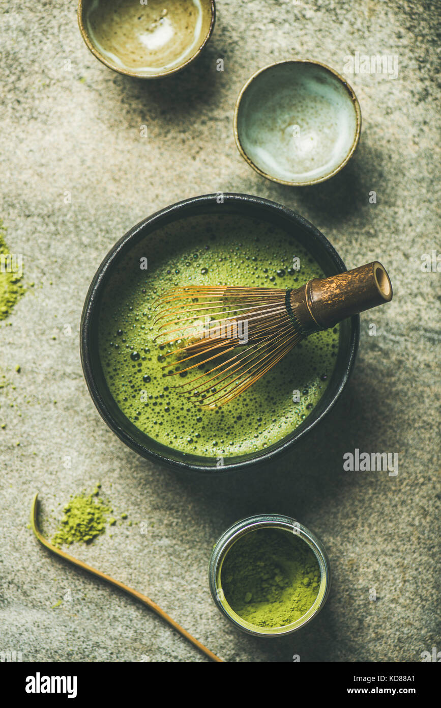 Flat-lay of Japanese tools for brewing matcha tea. Matcha powder in tin can, Chashaku spoon, Chasen bamboo whisk, Chawan bowl and cups for ceremony ov Stock Photo