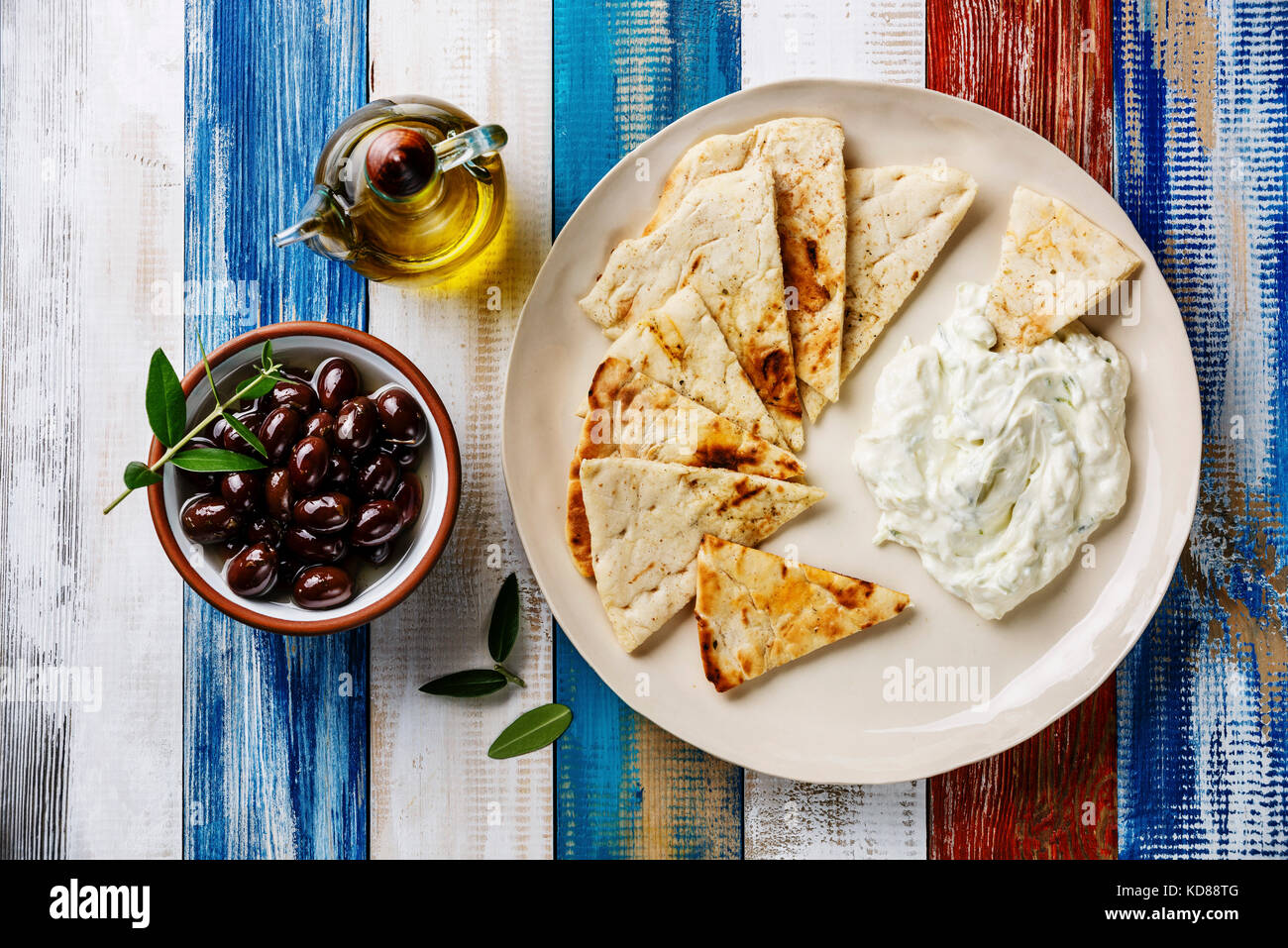 Yogurt dip with herbs Dzadziki cacik sauce, Pita bread, Olive oil and Olives on wooden background Stock Photo