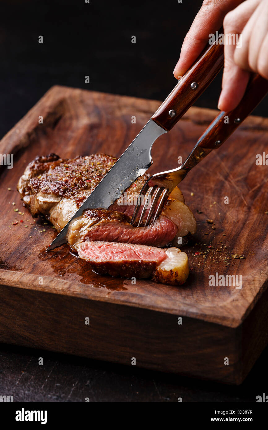 Sliced grilled meat steak New York Striploin with knife and fork in