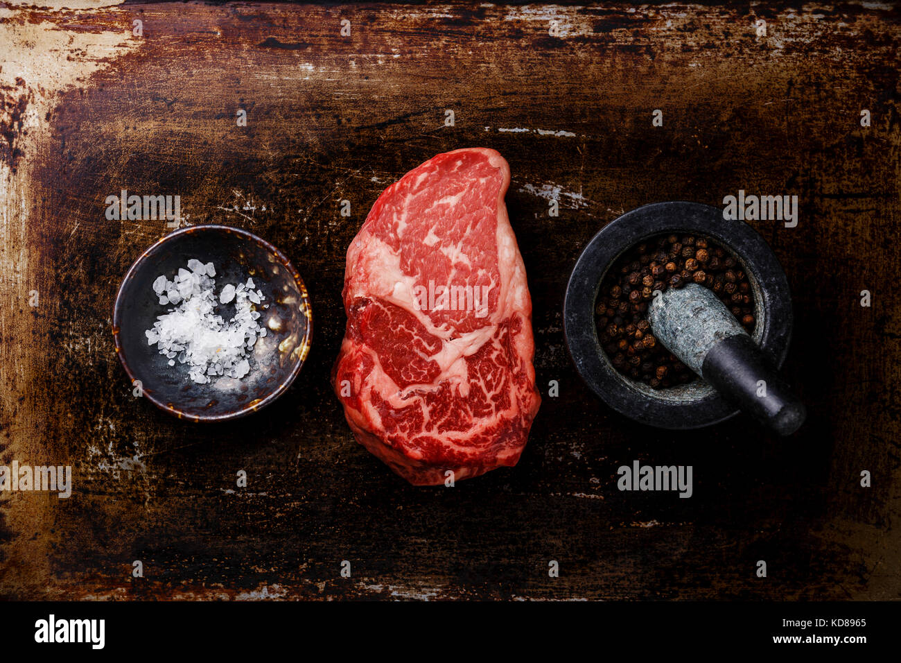 Raw fresh marbled meat Steak Rib eye Black Angus and seasoning on dark metal background Stock Photo