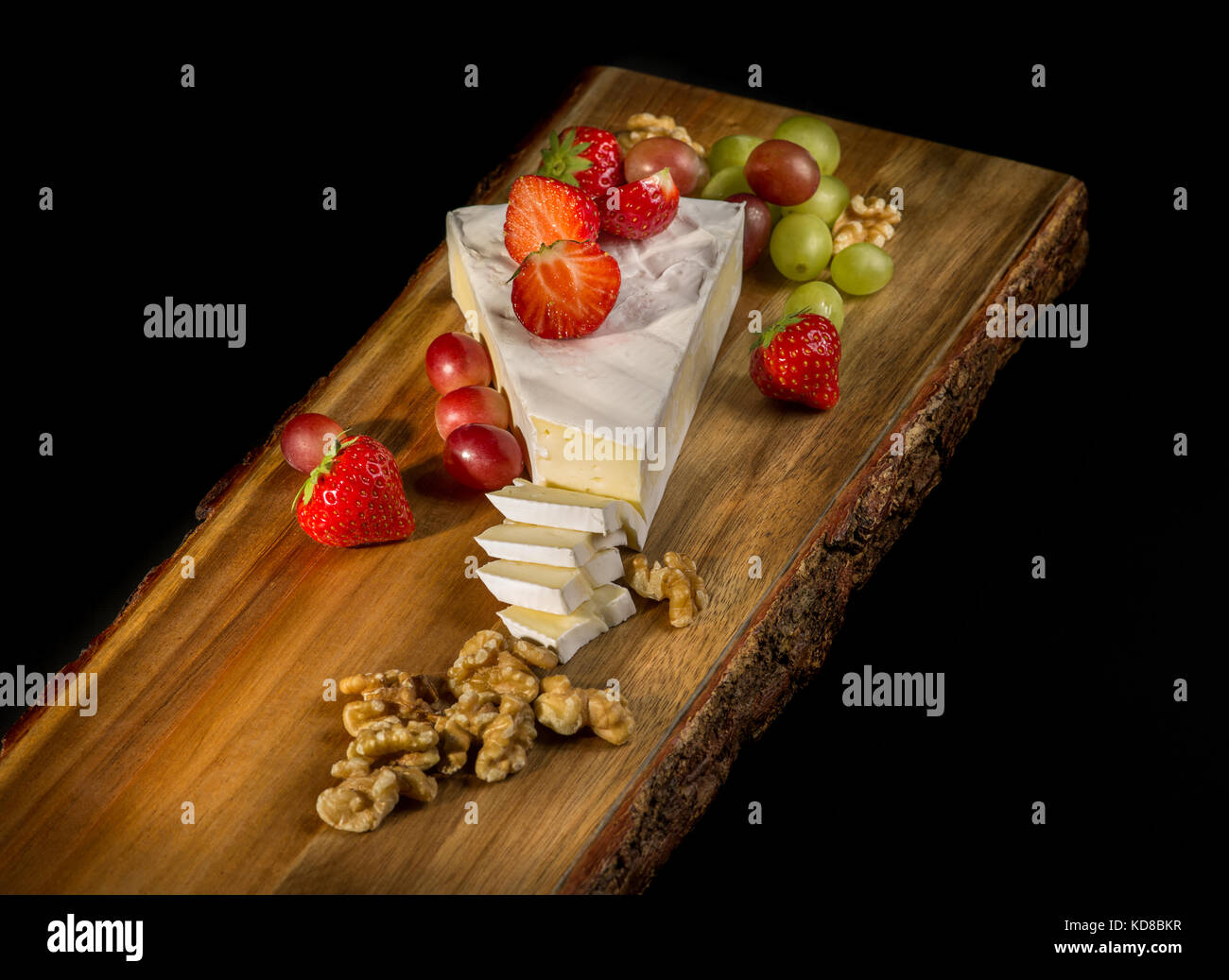 Brie cheese with walnuts, grapes and strawberries Stock Photo