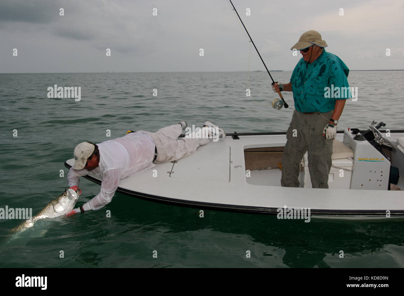 Fly-fisherman waiting with fishing pole on shoulder Stock Photo - Alamy