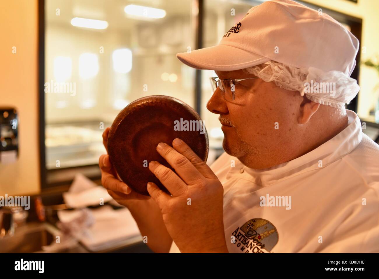 Wisconsin Master Cheesemaker Mike Brennenstuhl nosing cheese round at