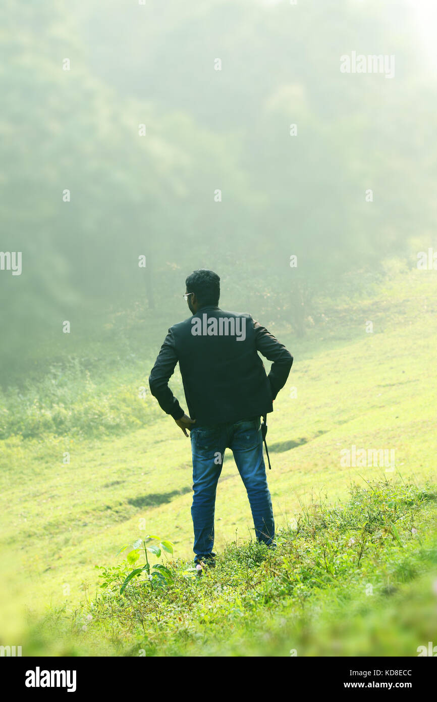 Happy businessman standing pose and turning back upon camera. With a  beautiful green scenery of park on background Stock Photo - Alamy