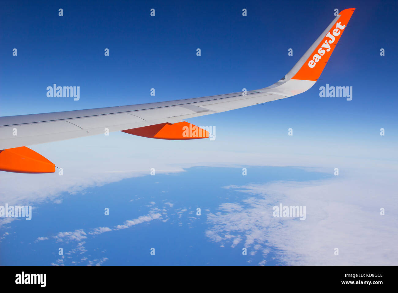 The wing and winglets of an Airbus A320 commercial airliner with a company logo while in flight Stock Photo