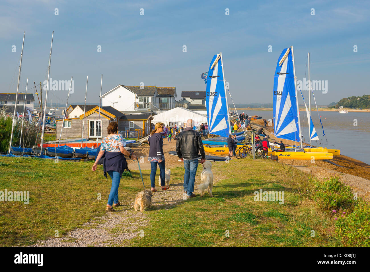 Suffolk coastal path, people walking their dogs along the coastal path at the estuary of the River Deben approach the Felixstowe Ferry Sailing Club,UK Stock Photo