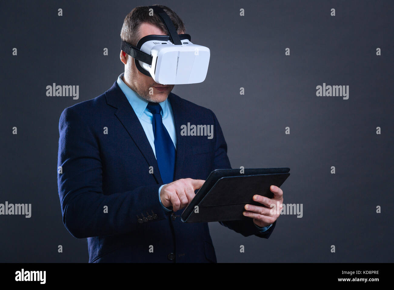 Handsome successful businessman using a tablet Stock Photo - Alamy