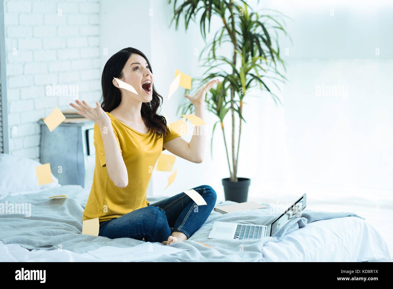 Excited girl throwing paper notes on bed Stock Photo - Alamy