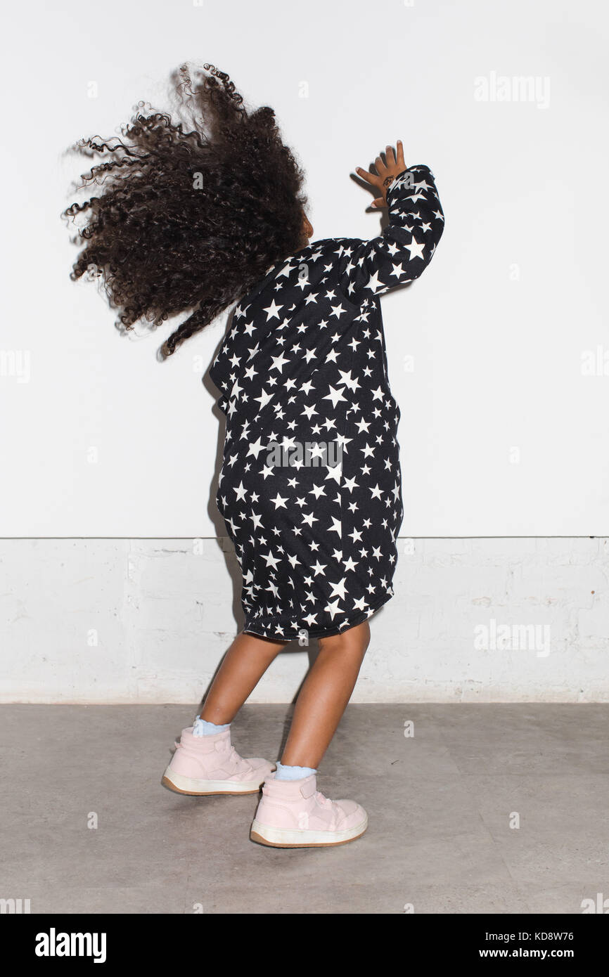 Black kid in dress dancing in studio on a white background Stock Photo