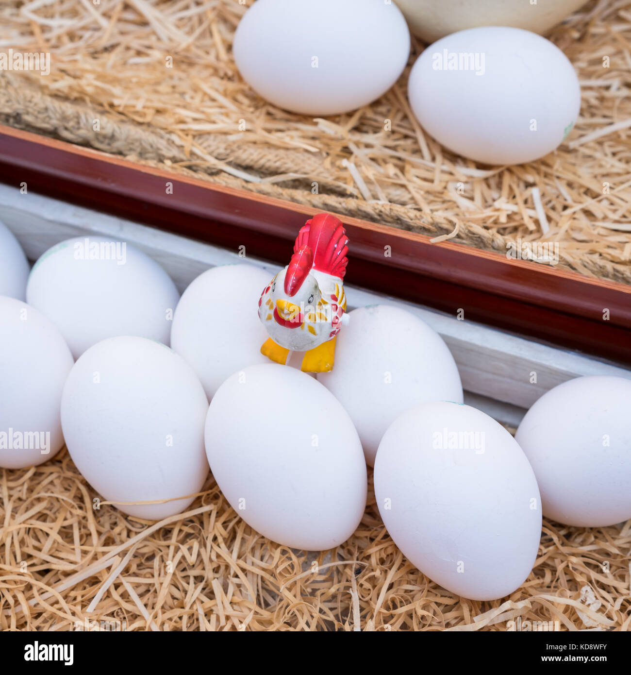 White chicken eggs leaning on straw in wooden basket,close up Stock ...