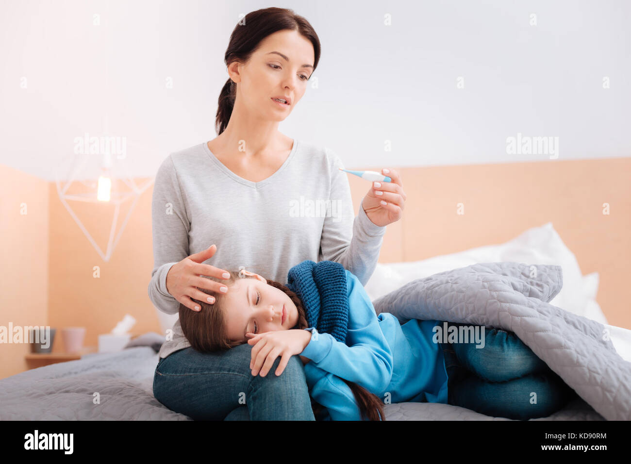 Ill child on the knees of a worried mother Stock Photo