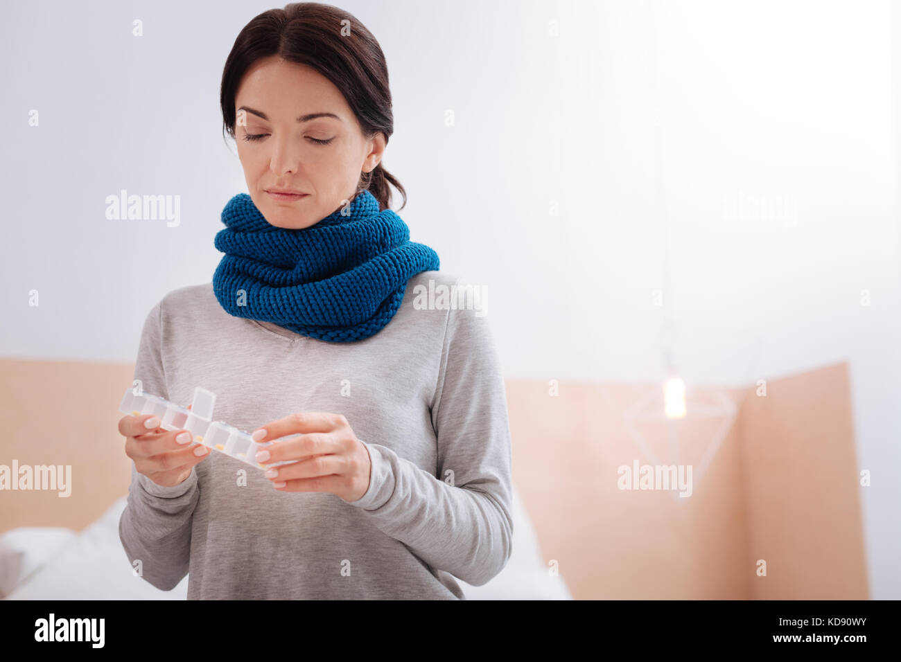 Thoughtful ill woman counting the pills in a pillbox Stock Photo