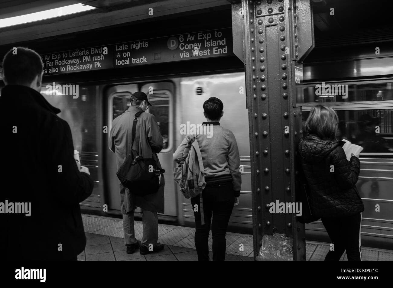 Commuters of New York City calmly waiting for their next train in the subway in Manhattan Stock Photo