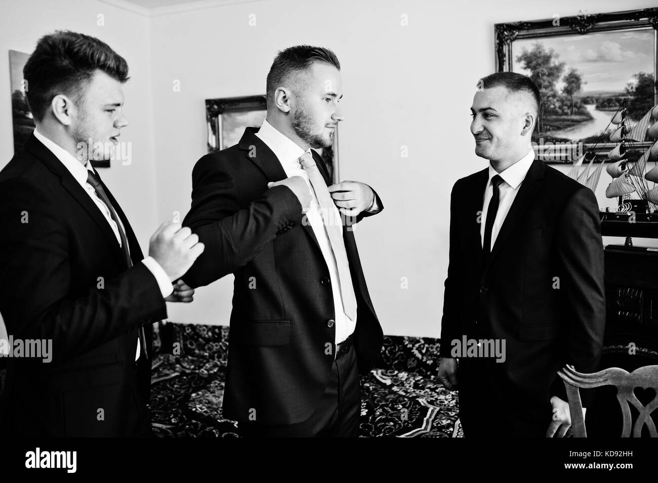 Groomsmen Helping Groom To Dress Up For His Wedding Ceremony Stock